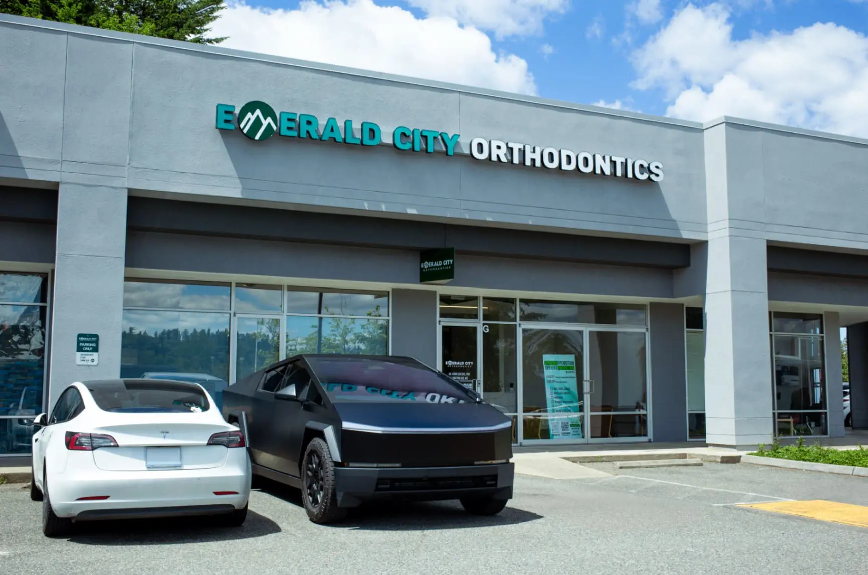 Two cars are parked outside Emerald City Orthodontics in Kirkland WA, on a sunny day.