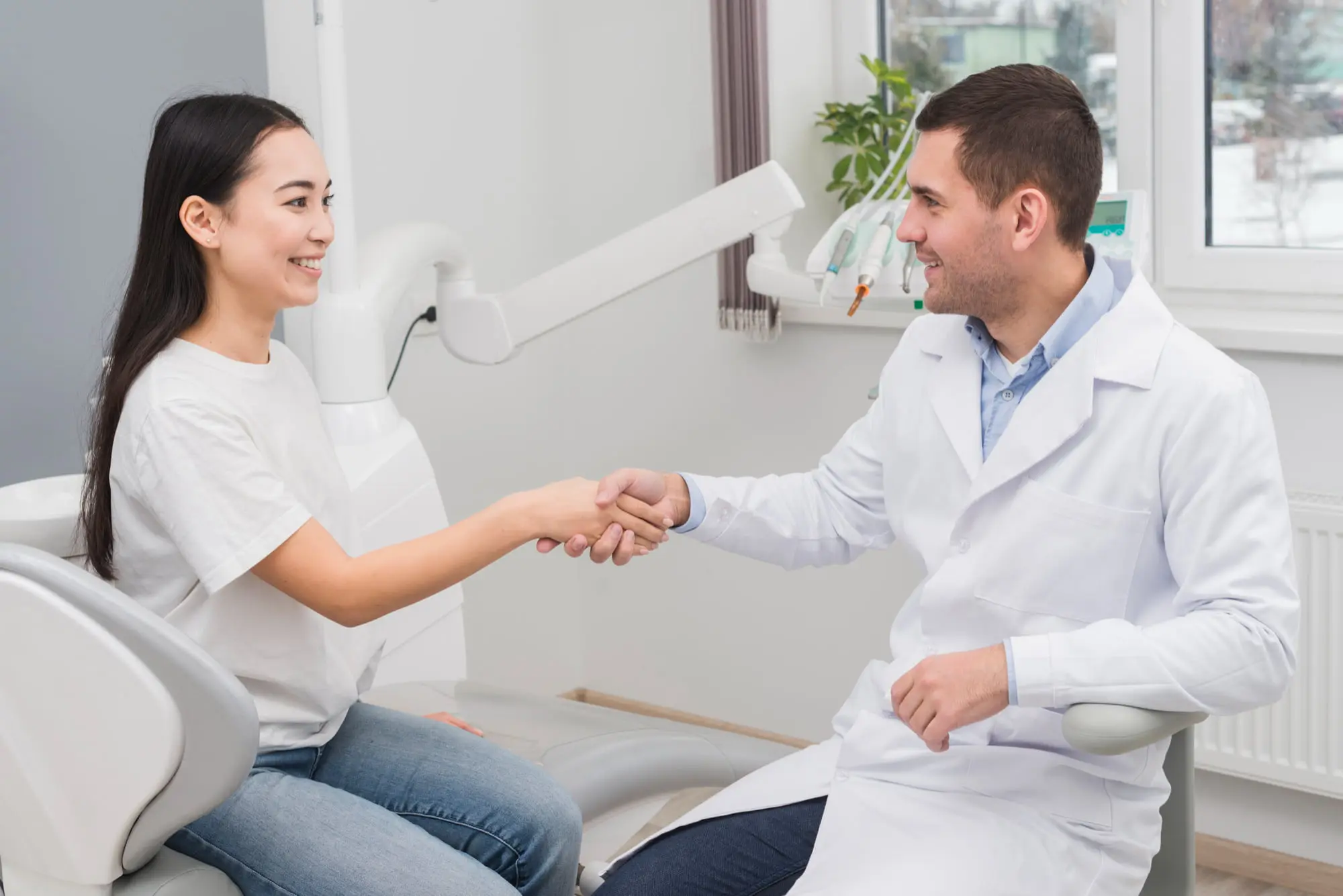 A dentist greets a patient in a dental chair, showcasing Emerald City Orthodontics adult services in Kirkland, WA.