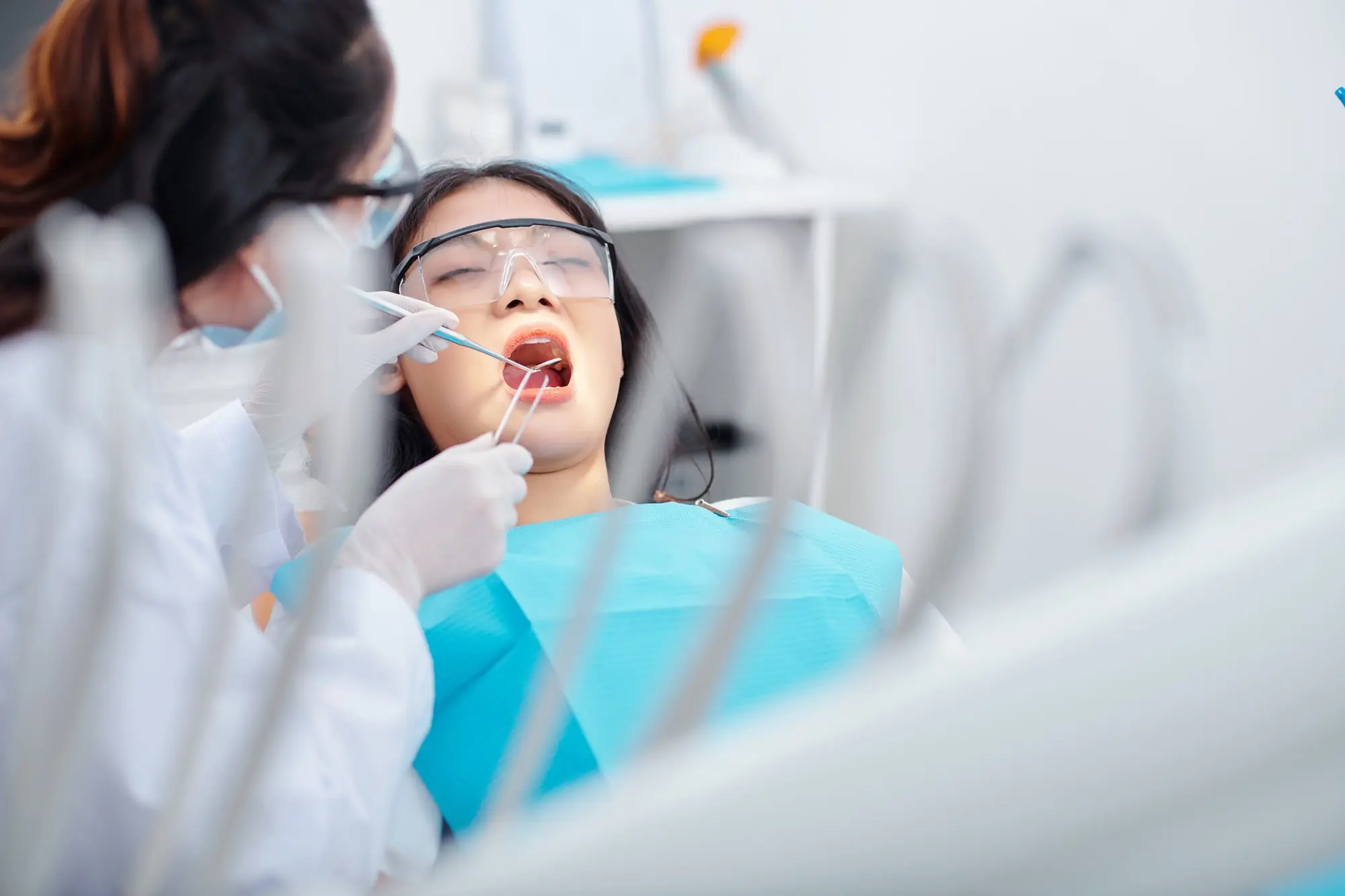 In a clinic, a dentist checks for an underbite as the patient wears protective glasses at Emerald City Orthodontics in Kirkland, WA.