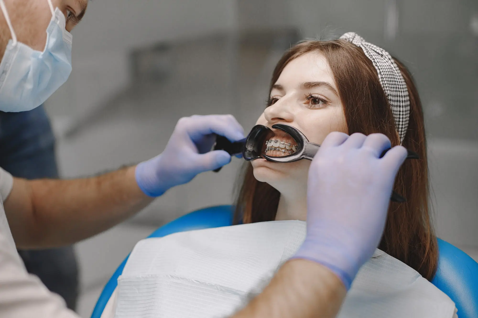 At Emerald City Orthodontics in Kirkland WA, a dentist examines a patient's teeth using adult orthodontic tools and techniques.