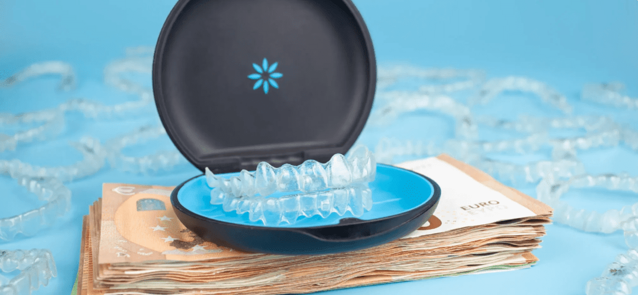 A clear aligner in a case sits on euro banknotes, suggesting Invisalign cost at Emerald City Orthodontics in Kirkland, WA.
