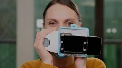 Indoors, a person holds a high-tech medical device with a smartphone attached at Emerald City Orthodontics in Kirkland, WA.