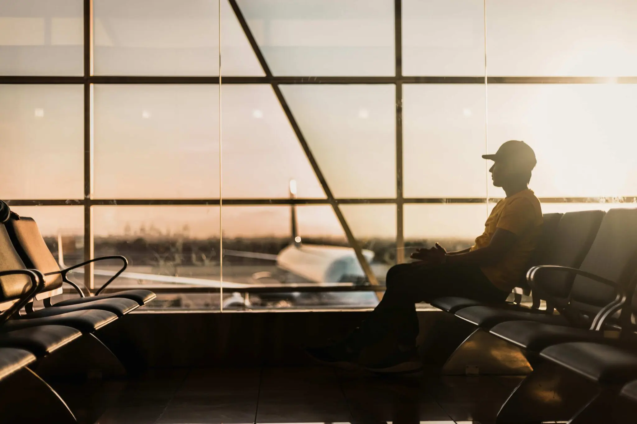 At sunset in an empty airport, a person ponders Emerald City Orthodontics insurance in Kirkland, WA as a plane sits outside.