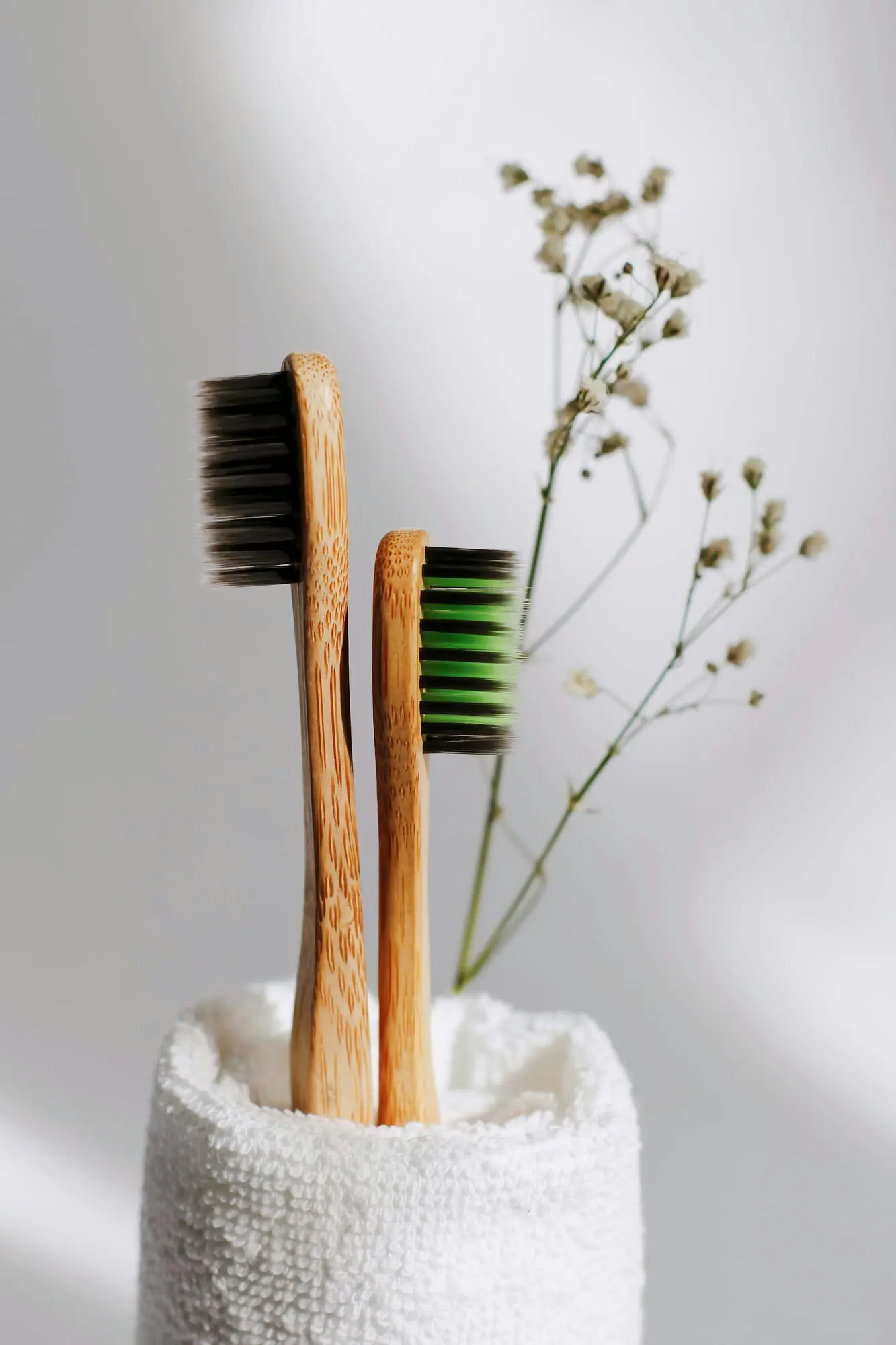 In Kirkland, WA, Emerald City Orthodontics displays two bamboo toothbrushes in a rolled towel with white flowers in the background.