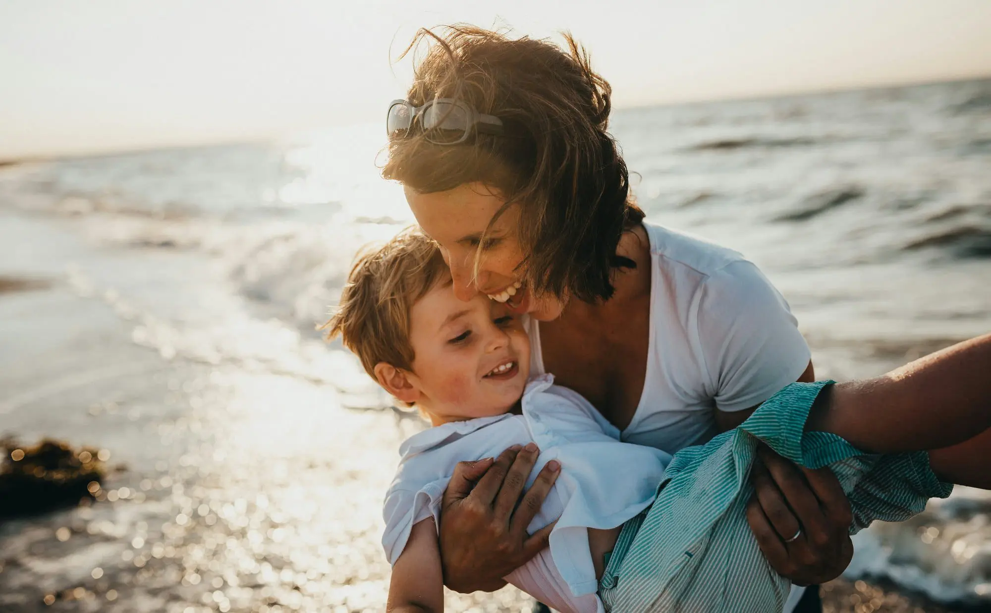By the seaside in Kirkland WA, an adult and a smiling child show off a Herbst Appliance from Emerald City Orthodontics.