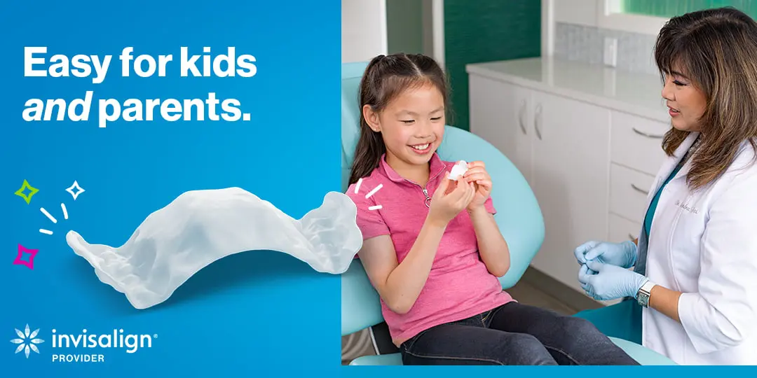 A young girl smiles at a dental aligner in a clinic as a professional sits by. Emerald City Orthodontics in Kirkland, WA. Invisalign Palatal Expander logo and "Easy for kids and parents" text visible.