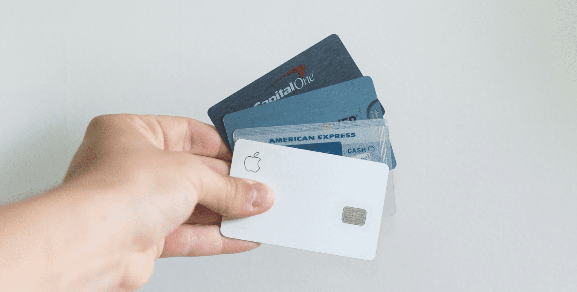 A hand holds four credit cards, convenient for Invisalign Payment Plans at Emerald City Orthodontics in Kirkland, WA.